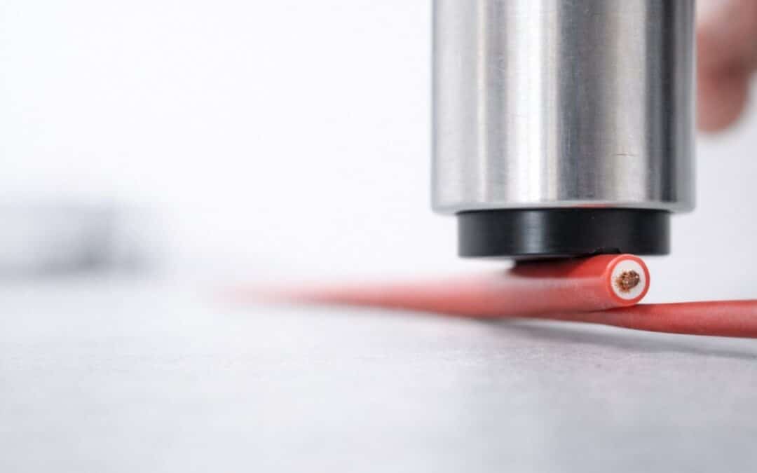 Messkopf eines Spektralphotometers bei der Farbmessung an einem roten Kabel